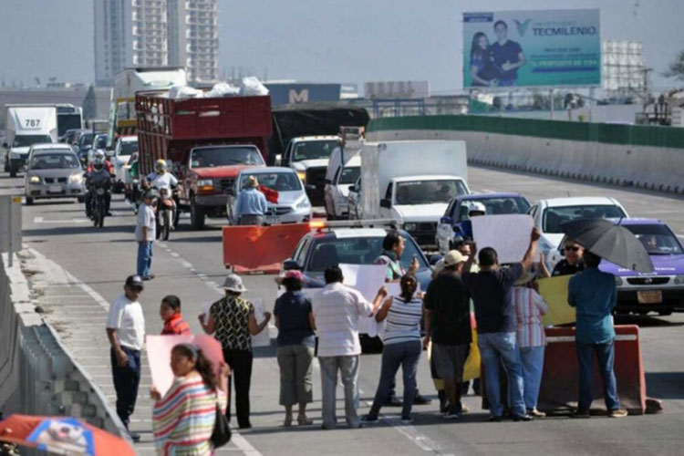 Bloquean vecinos Paso Exprés por incumplimiento de SCT
