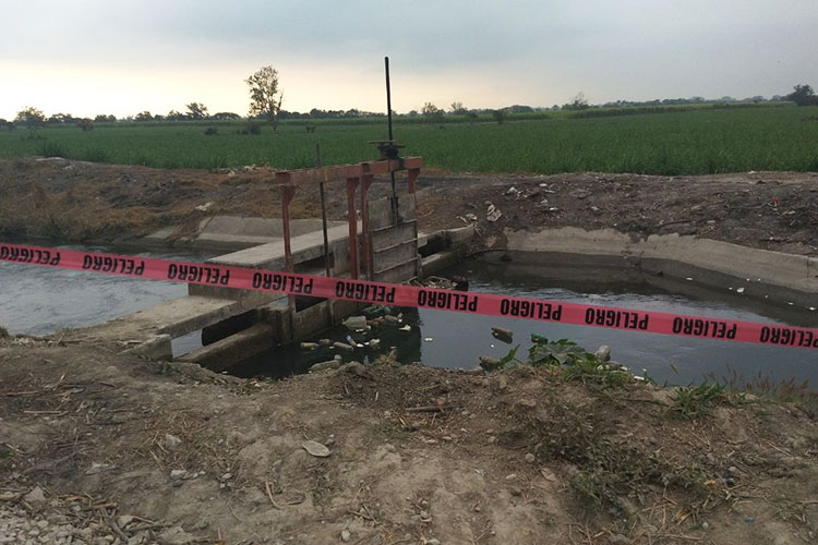 Flota hombre en canal de riego